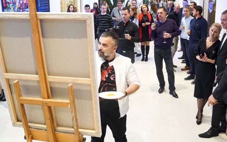 Joe Muczka jr. at the easel in front of guests at the New Living Centrum