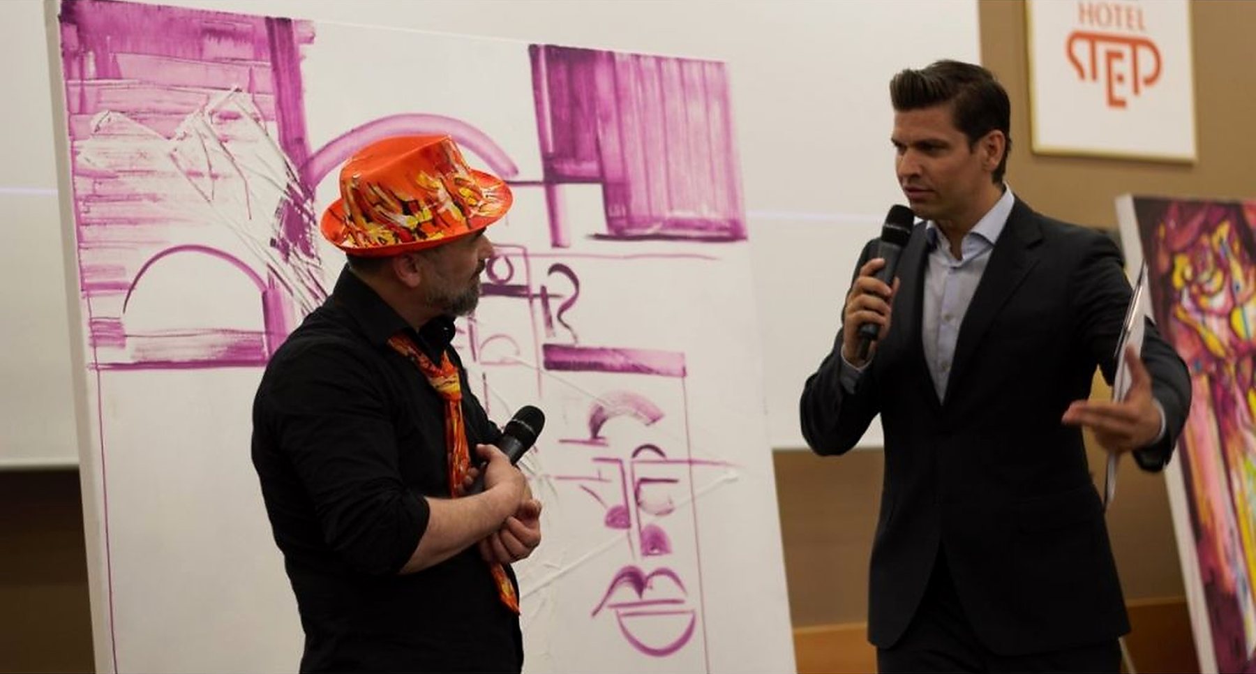 Joe Muczka jr. im Gespräch vor einem Werk, das er soeben vor Publikum gemalt hat